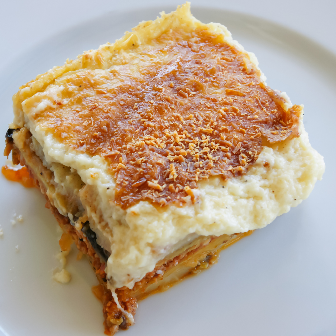 A piece of lasagna on top of a white plate.