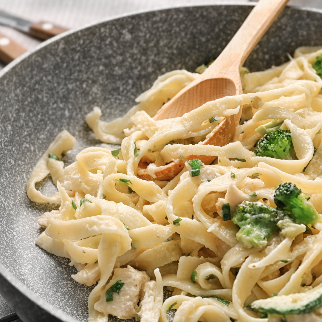 A bowl of noodles with broccoli and cheese.